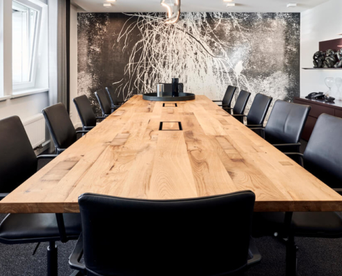 Holz-Konferenztisch mit schwarzen Lederstühlen