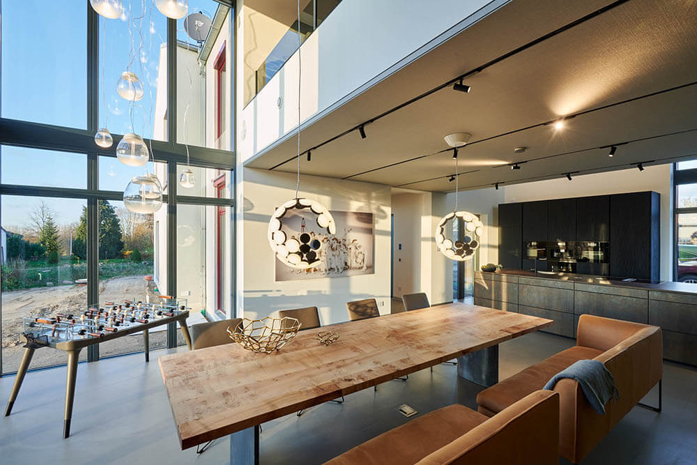 Großzügiger, offener Essbereich mit hohen Glasfronten und Designertisch – moderne Architektur und Inneneinrichtung für hohe Ansprüche.